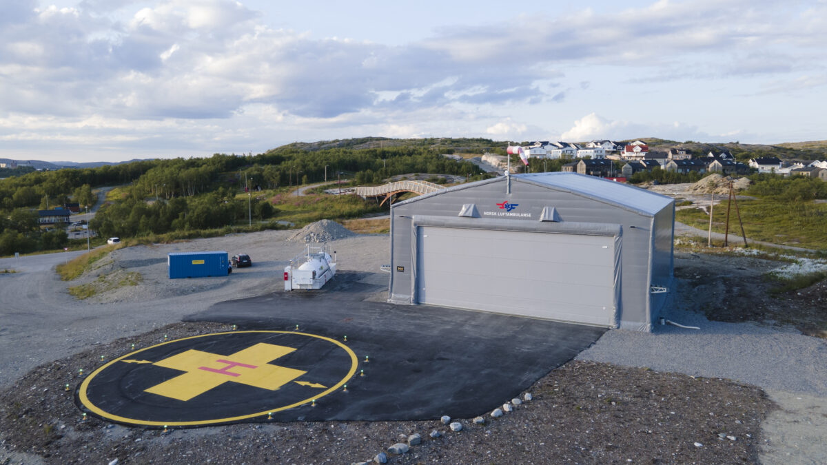 A modern hangar with a helicopter landing pad in the foreground, perfect for air ambulance operations. Hallgruppen built this facility for efficient and safe use.